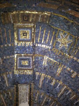 Bei der Umgestaltung der Kirche in den 60er Jahren wurde das "P" entfernt und durch Smalten ergänzt. Zum Teil wurden die Smalten dann mit Farbe bemalt um sie farblich anzupassen. Umgestaltung des Wandmosaiks in St.Thomas von Aquin in den 60er Jahren.